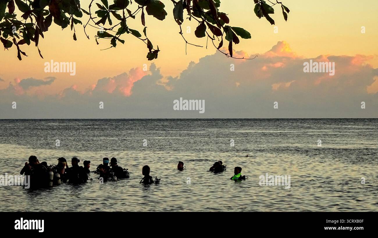 Gruppe von Tauchern, die sich im Wasser auf einen frühen Tauchgang am U.S.A.T. Liberty Wrack an der Nordküste von Bali, Tulamben, vorbereiten Stockfoto