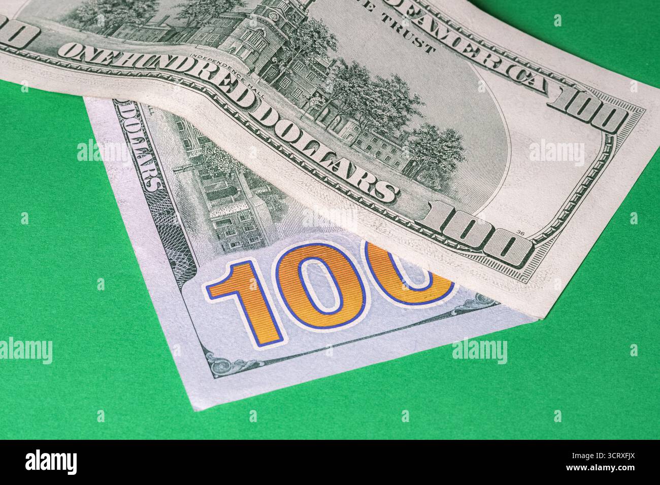 Nahaufnahme alter und neuer US-Dollar-Scheine auf grünem Hintergrund. Die detaillierte Währung und der grün leuchtende Hintergrund werden hervorgehoben. Konzept des Finan Stockfoto