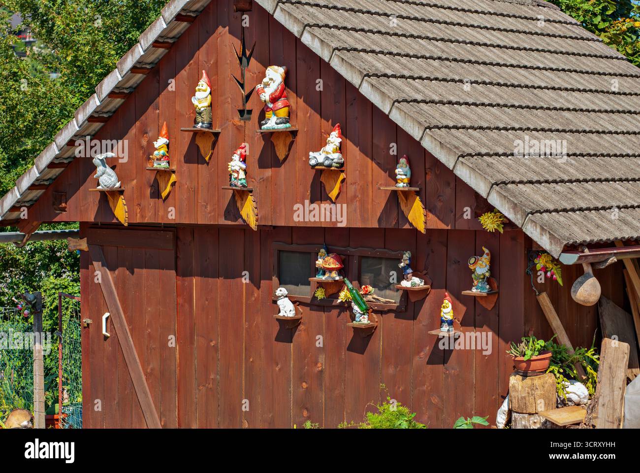 Gartenzwerge auf Holzschuppen-Wand, rustikale Outdoor-Kollektion Stockfoto