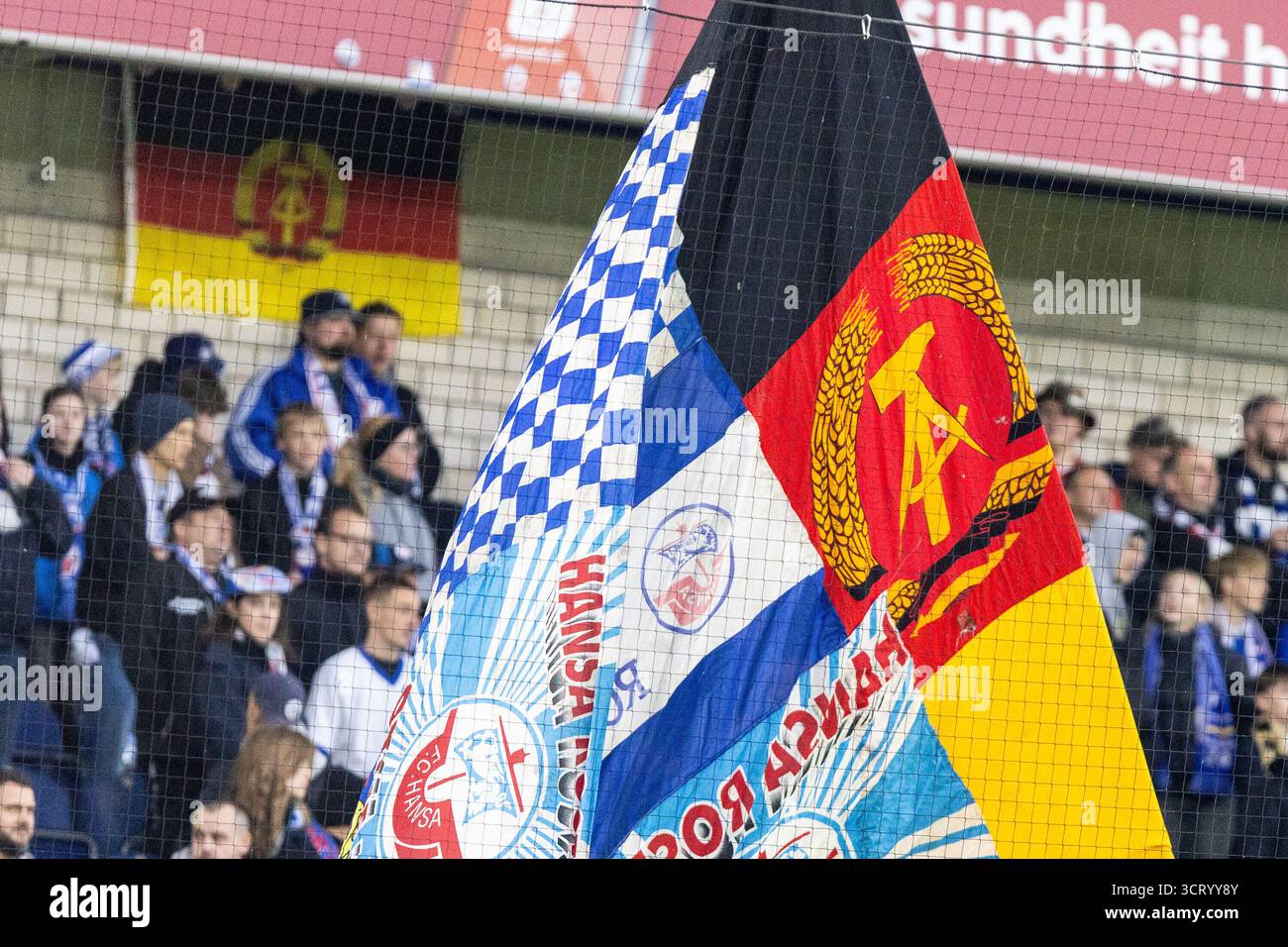 Duisburg, Deutschland. Oktober 2025. Fans von FC Hansa Rostock, Flagge mit dem Logo von DDR (Deutsche Demokratische Republik). 3.Liga 10.Spieltag: MSV Duisburg - FC Hansa Rostock; Schauinsland-Reisen-Arena, Duisburg; 03.10.2025 DFB-Vorschriften verbieten jede Verwendung von Fotografien als Bildsequenzen und/oder Quasi-Video. Quelle: dpa/Alamy Live News Stockfoto