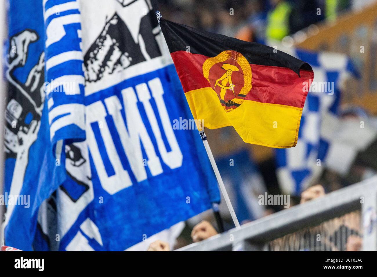 Duisburg, Deutschland. Oktober 2025. Fans von FC Hansa Rostock, Flagge mit dem Logo von DDR (Deutsche Demokratische Republik). 3.Liga 10.Spieltag: MSV Duisburg - FC Hansa Rostock; Schauinsland-Reisen-Arena, Duisburg; 03.10.2025 DFB-Vorschriften verbieten jede Verwendung von Fotografien als Bildsequenzen und/oder Quasi-Video. Quelle: dpa/Alamy Live News Stockfoto