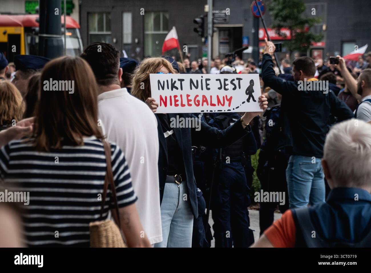 Frau mit einem Banner mit dem Slogan „Niemand's illegal“ in polnischer Sprache während einer Linken, die die Einwanderung in Warschau unterstützt Stockfoto