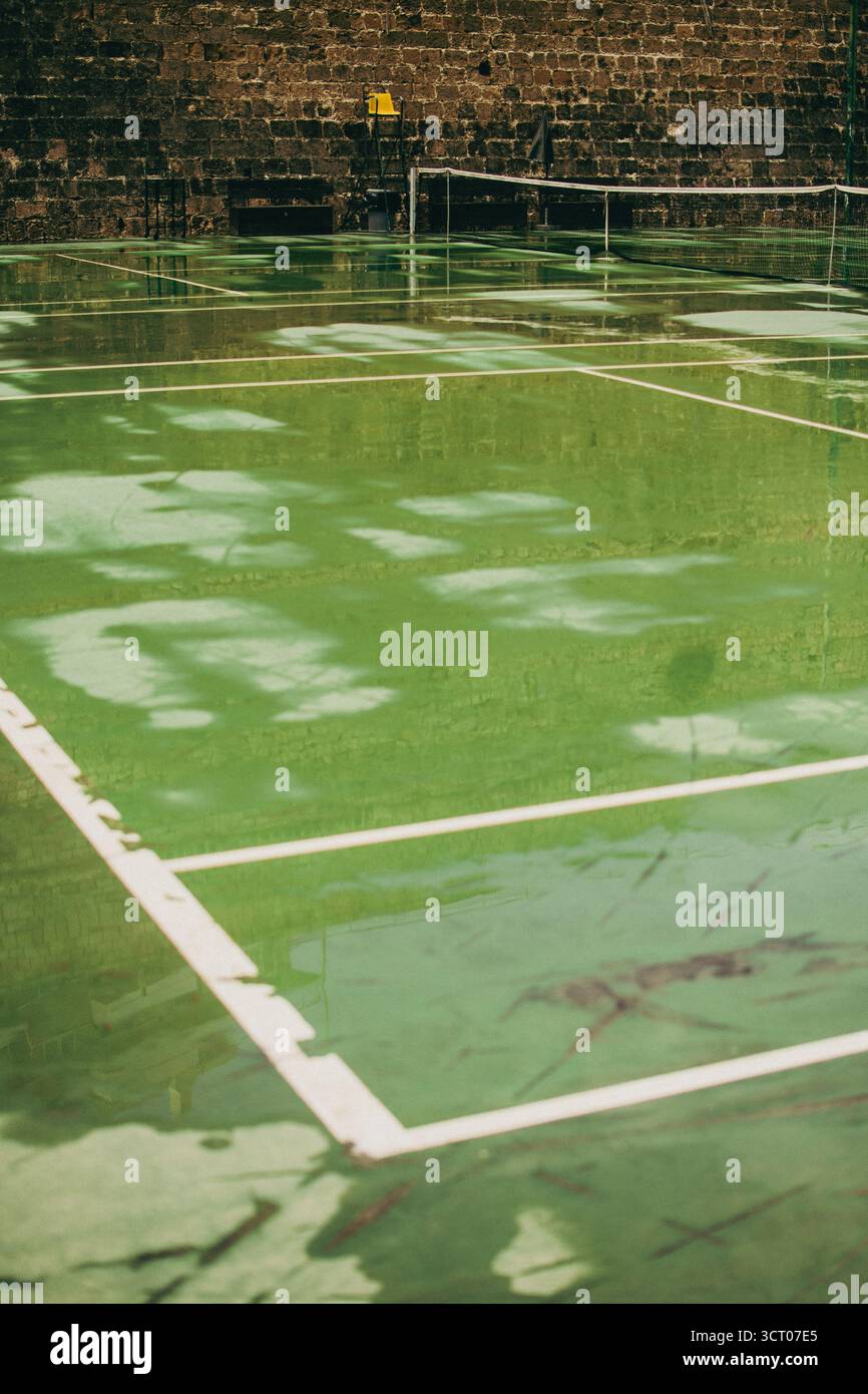 Ein ruhiger Tennisplatz in Heraklion, Griechenland, ohne Spieler oder Ablenkungen. Die Szene betont klare Linien, offene Räume und die Geometrie von Stockfoto