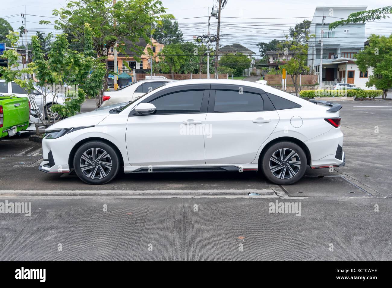 Weiße Sportlimousine und andere Parken auf dem offenen Parkplatz. Stockfoto