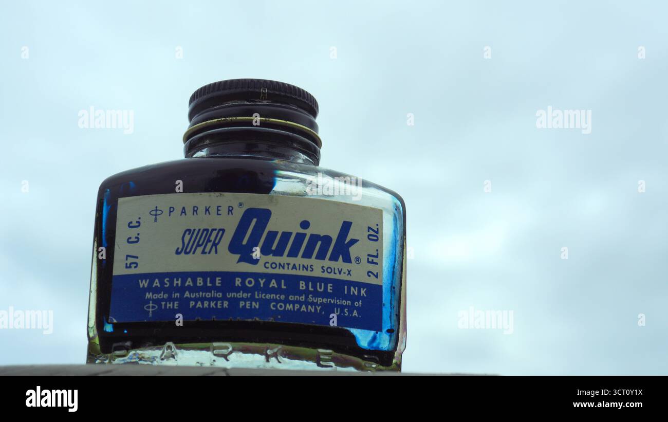 Niedriger Winkel einer Parker Ink Quink Flasche aus der Mitte des Jahrhunderts, mit getrocknetem Füllfederhalter königsblauer Tinte und imperialer Messung des Inhalts Stockfoto