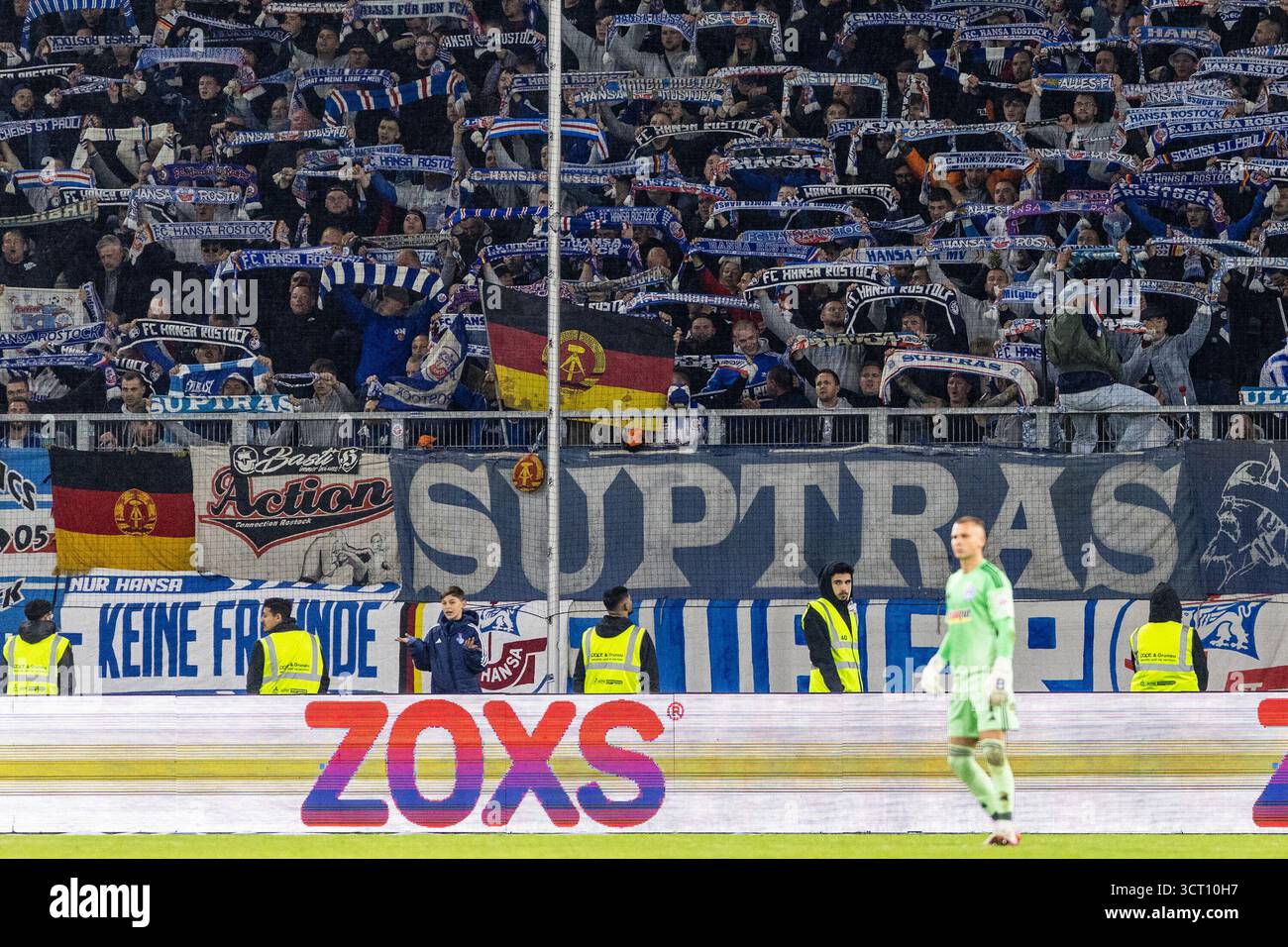 Duisburg, Deutschland. Oktober 2025. Fans von FC Hansa Rostock, Flagge mit dem Logo von DDR (Deutsche Demokratische Republik). 3.Liga 10.Spieltag: MSV Duisburg - FC Hansa Rostock; Schauinsland-Reisen-Arena, Duisburg; 03.10.2025 DFB-Vorschriften verbieten jede Verwendung von Fotografien als Bildsequenzen und/oder Quasi-Video. Quelle: dpa/Alamy Live News Stockfoto