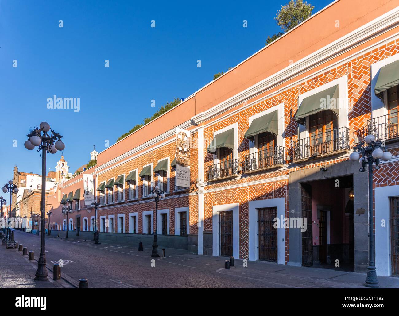 Eine Reihe von Gebäuden mit einer grünen Markise auf der Vorderseite. Die Gebäude sind alt und haben eine Ziegelfassade. Stadt Puebla, Mexiko, Kunsthandwerk Stockfoto
