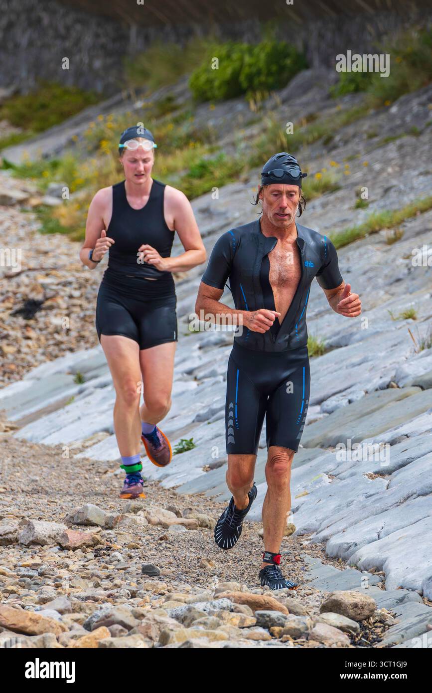 Sie laufen über den unebenen Strand in Little Harp Bay Stockfoto