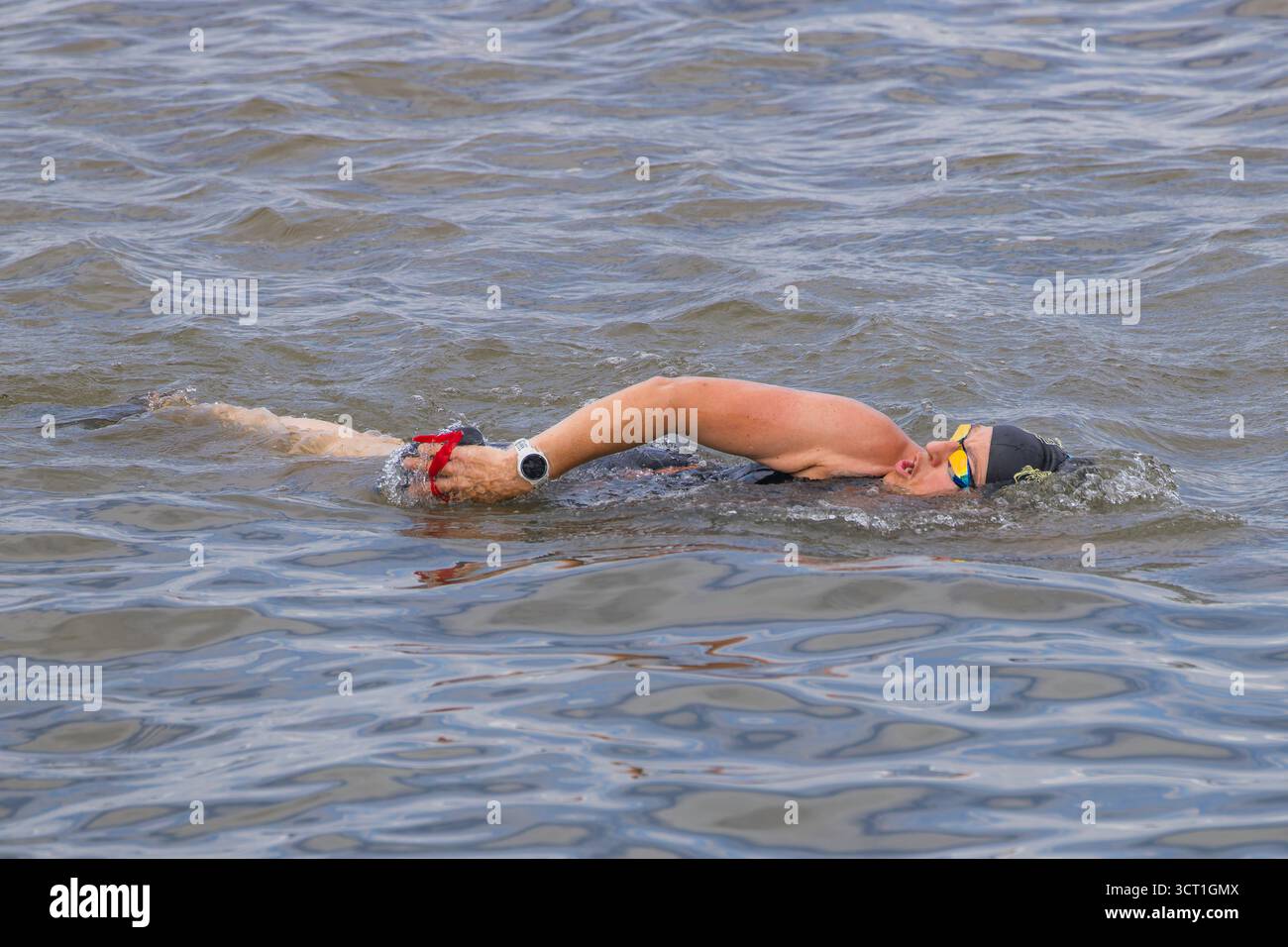 Ladt im Vollschwimmmodus mit Arm in der Luft und atmen Stockfoto