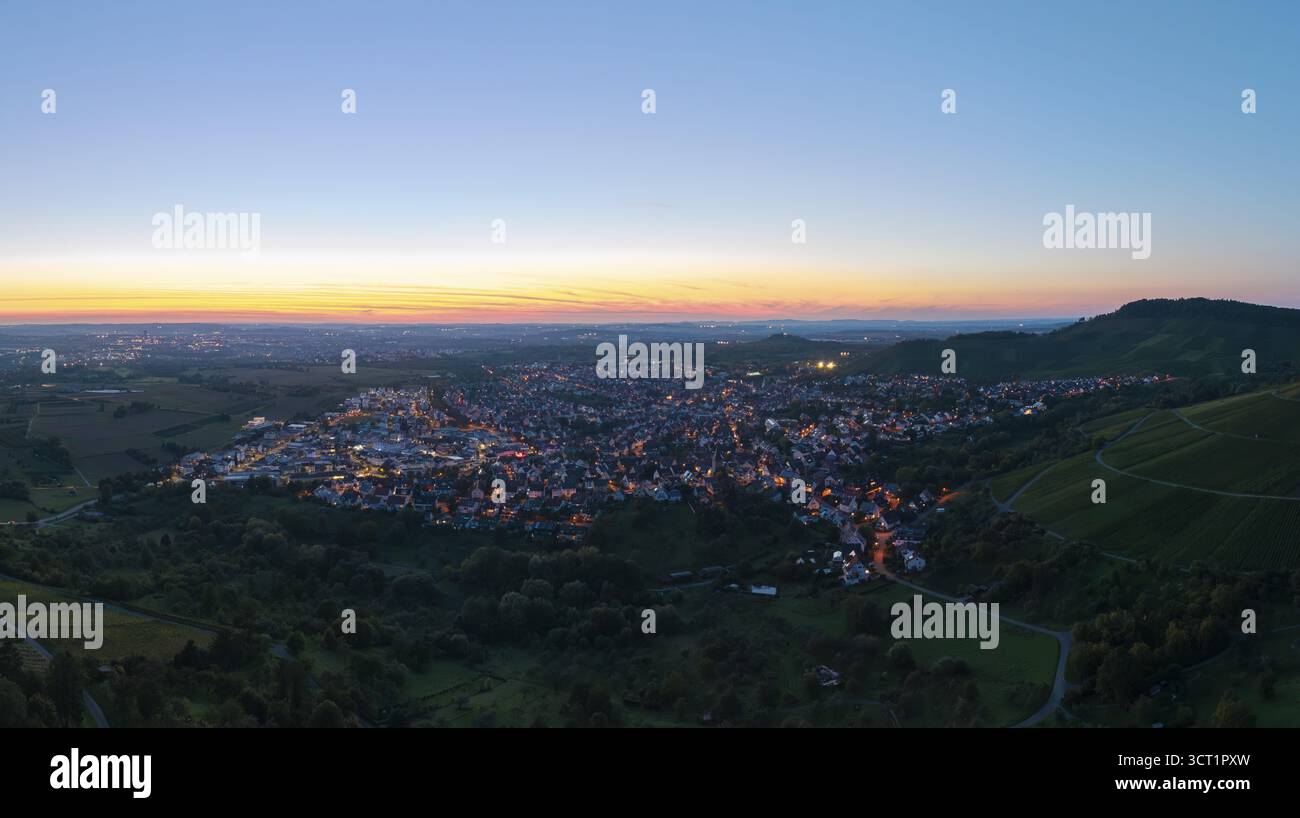 Panoramablick auf eine Stadt bei Sonnenuntergang, mit beleuchteten Straßen und umliegenden Hügeln, Korb im Remstal, Baden-Württemberg, Deutschland Stockfoto