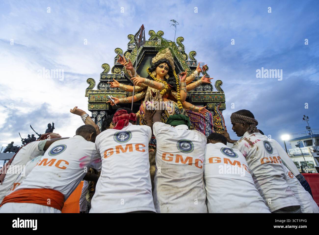 Stadtarbeiter schieben ein Tonidol der Göttin Durga, um am Schlusstag des Durga Puja Festivals in Guwahat in den Brahmaputra River einzutauchen Stockfoto