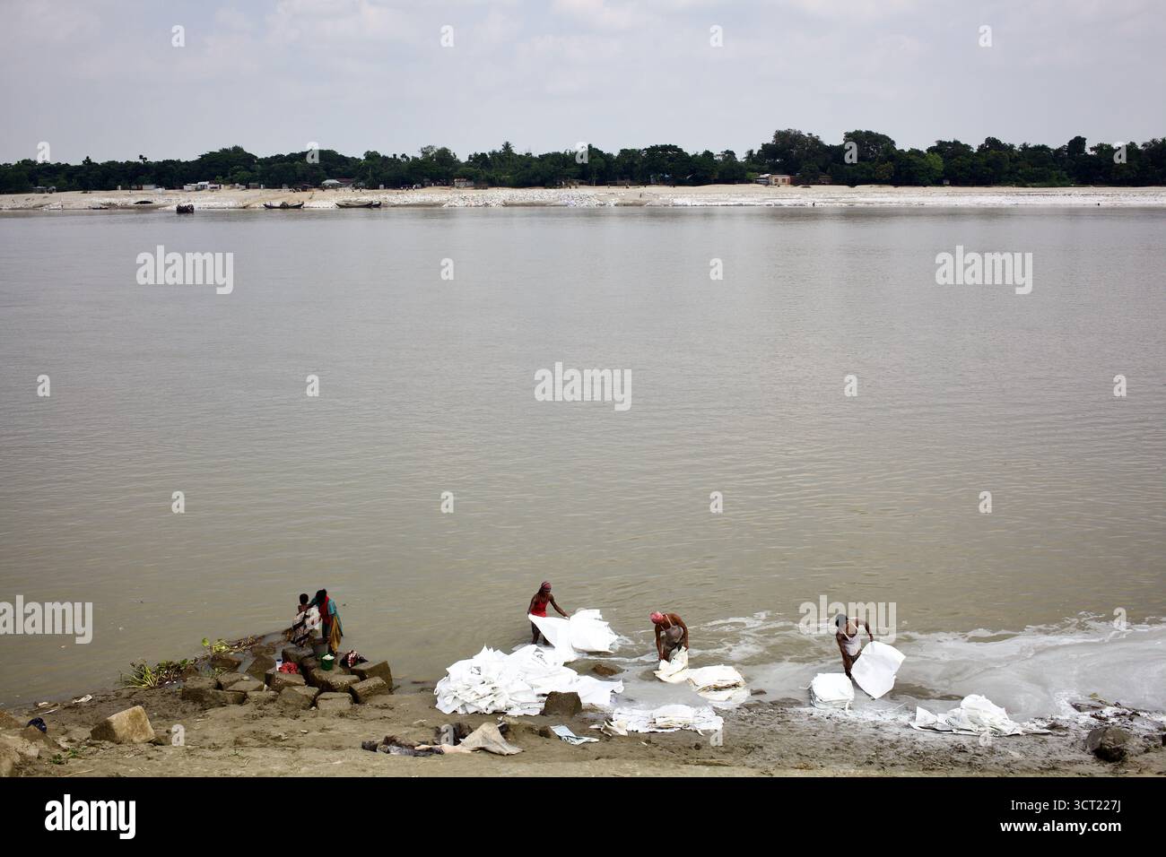 Arbeiter, die CGPC-Harz- und Betonsäcke am Ufer des Flusses Madhumati in Kushtia, Bangladesch, zur Reinigung und Wiederverwendung waschen. Stockfoto