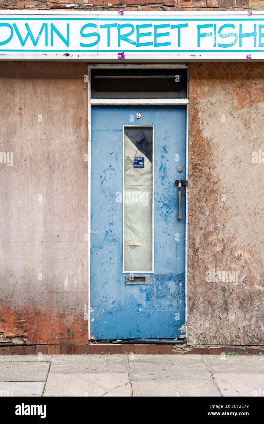 Schäbige blaue Tür mit Glasscheibe Stockfoto