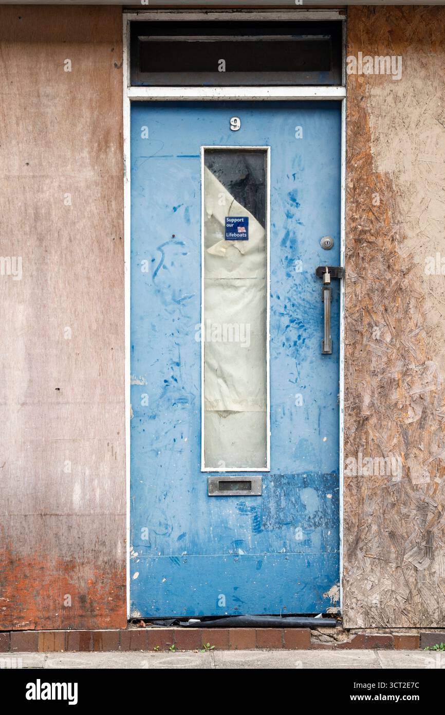 Schäbige blaue Tür mit Glasscheibe Stockfoto