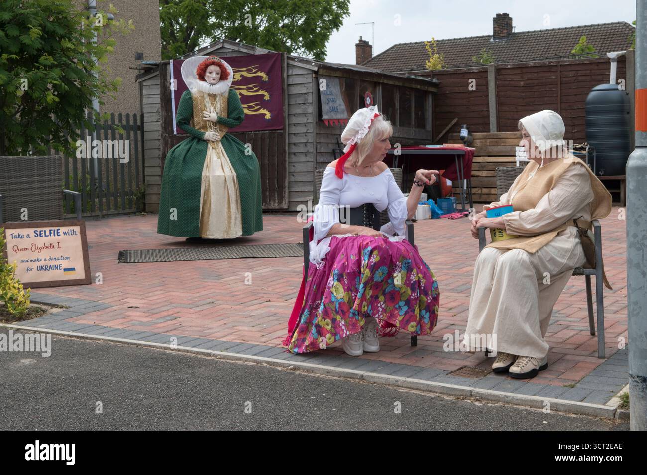 Für Geld für die Ukraine einsammeln. In elisabethanischer Zeit unterhalten sich Kostümfreunde in animierten Gesprächen, Besucher können ein Selfie mit Königin Elisabeth I. machen, Spenden werden gesammelt, um die Ukraine gegen die russische Aggression im sogenannten „Putins Krieg“ zu unterstützen. Corby Pole Fair. Corby Old Village, Northamptonshire, England 3. Juni 2022 2020, Vereinigtes Königreich HOMER SYKES Stockfoto
