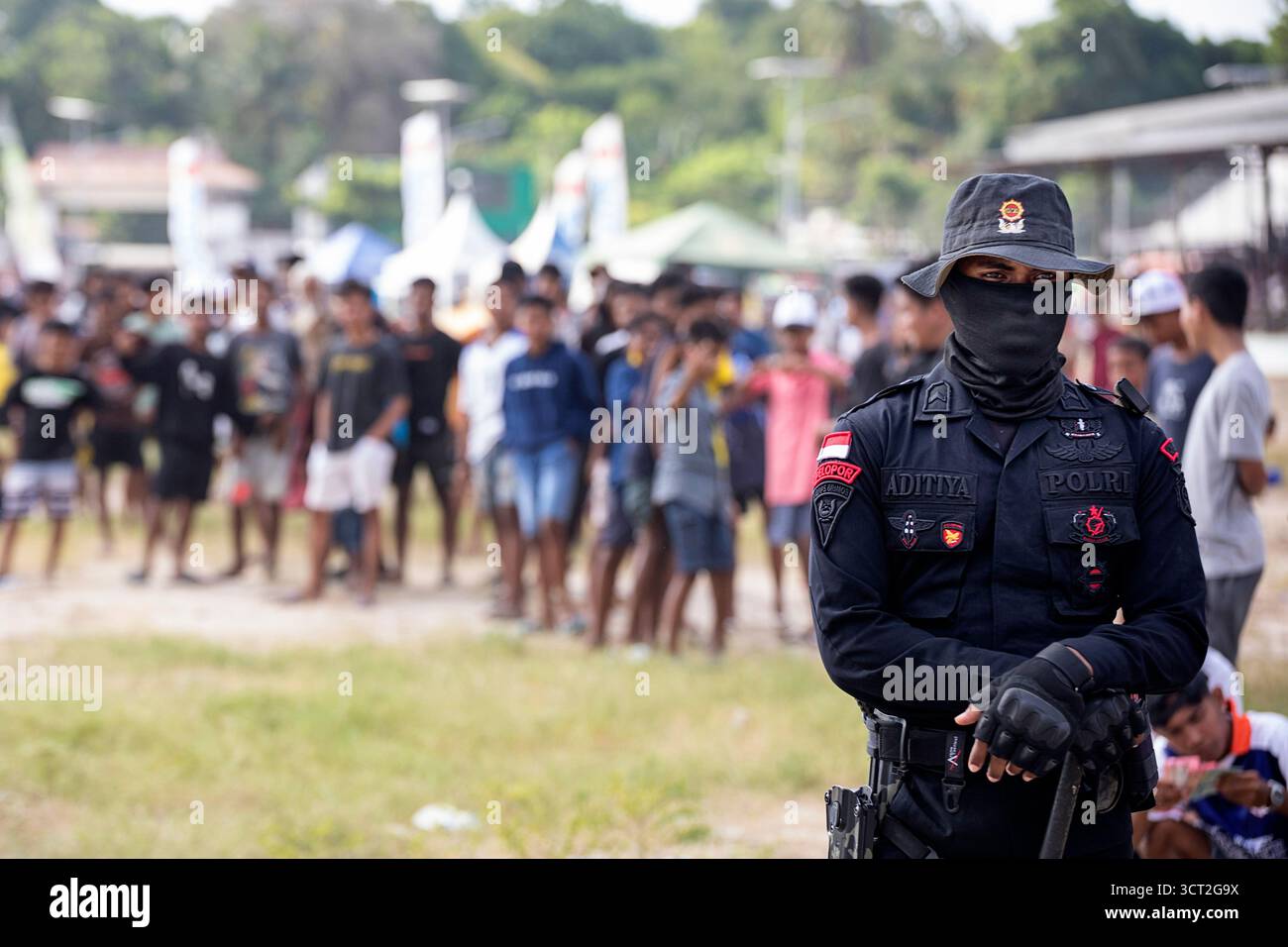 Traditionelle Pferderennen in einer Stadt Waingapu auf der indonesischen Insel Sumba, wobei sich der örtliche Polizeibeamte um die Sicherheit der Veranstaltung kümmert Stockfoto