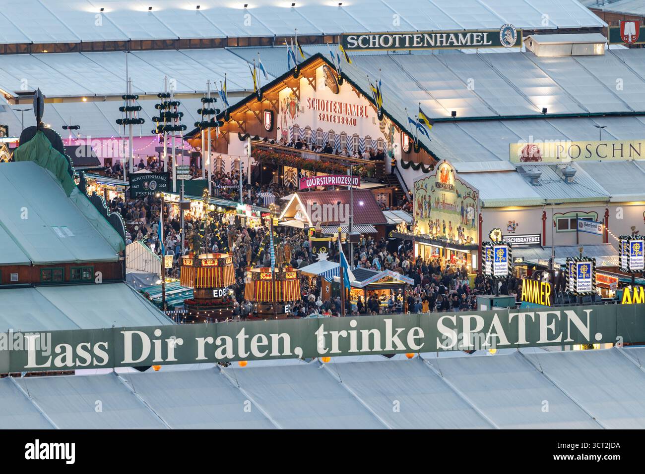 02. Oktober 2025, Bayern, München: Zahlreiche Besucher und das Festzelt der Schotenhamel-Brauerei (Spatenbräu) sind am 2. Oktober 2025 auf dem Oktoberfest auf der Theresienwiese in München zu sehen, während im Vordergrund die Worte „Take a ratet, Drink Spaten“ zu lesen sind. Die sogenannte Wiesn auf dem Oktoberfestgelände ist das größte Volksfest der Welt und dauert rund zwei Wochen, bei dem Millionen Menschen mit bayerischer Musik, Fahrgeschäften, Trachten wie Dirndl und Lederhosen und Bier feiern. (Übersicht, Vogelperspektive des Festivalgeländes, Symbolbild, Stockfoto