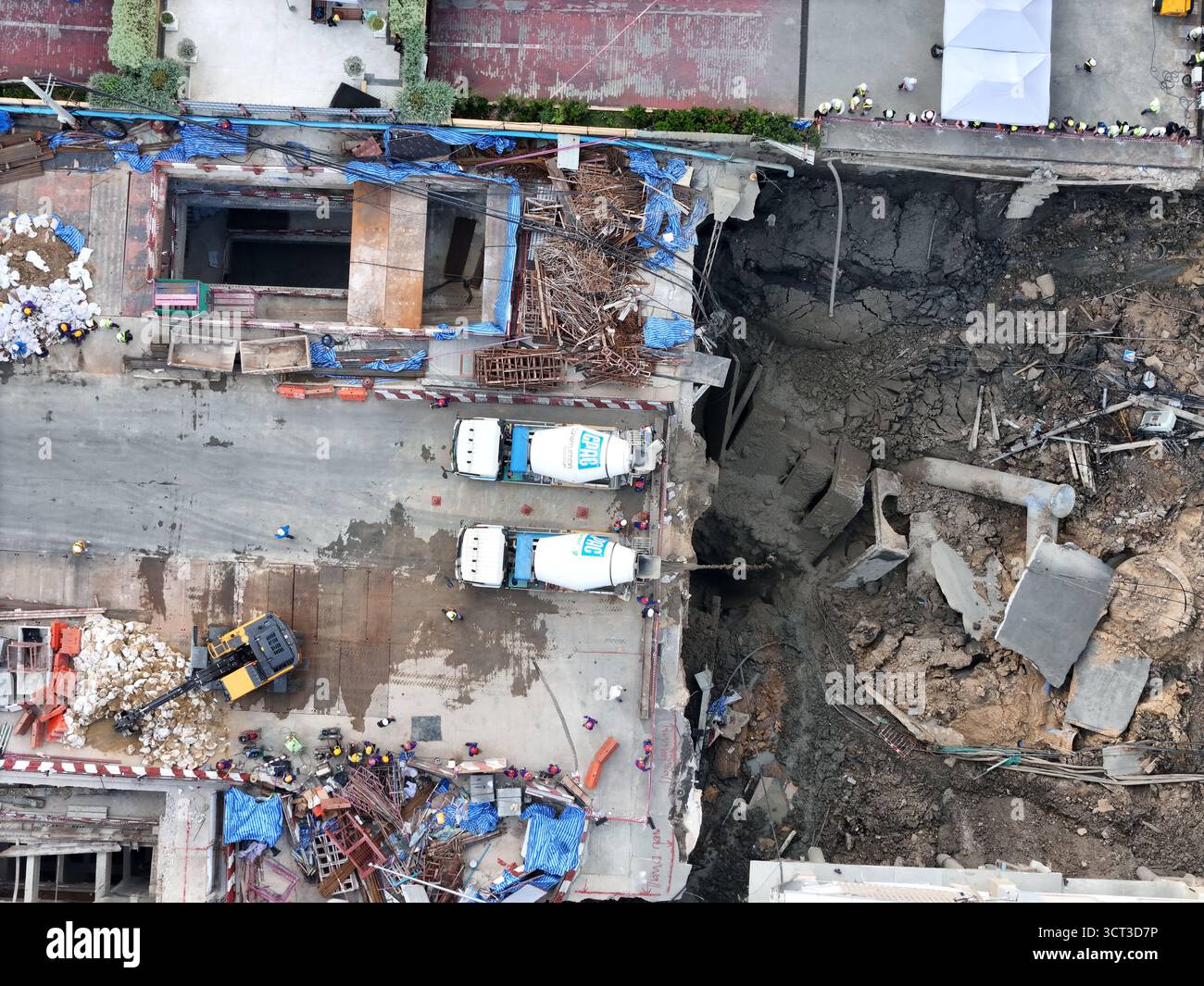 Bangkok (BKK), Thailand – 25.09.2025: Luft von Baumannschaften und Zementwagen neben dem Sinkloch der Samsen Road in der Nähe des Vajira Hospital in der DUS von Bangkok Stockfoto