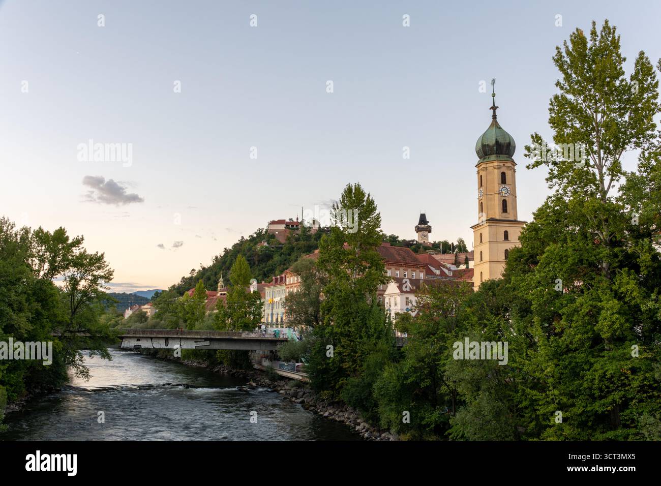 Graz, Österreich - 1. September 2025: Abendlicher Blick auf Graz mit Mur und Schlossberg von der Tegetthoff-Brücke Stockfoto