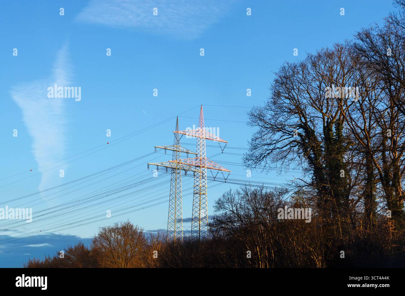 Zwei Große Rosafarbene Hochspannungsmasten Gegen Den Klaren Blauen Himmel Stockfoto