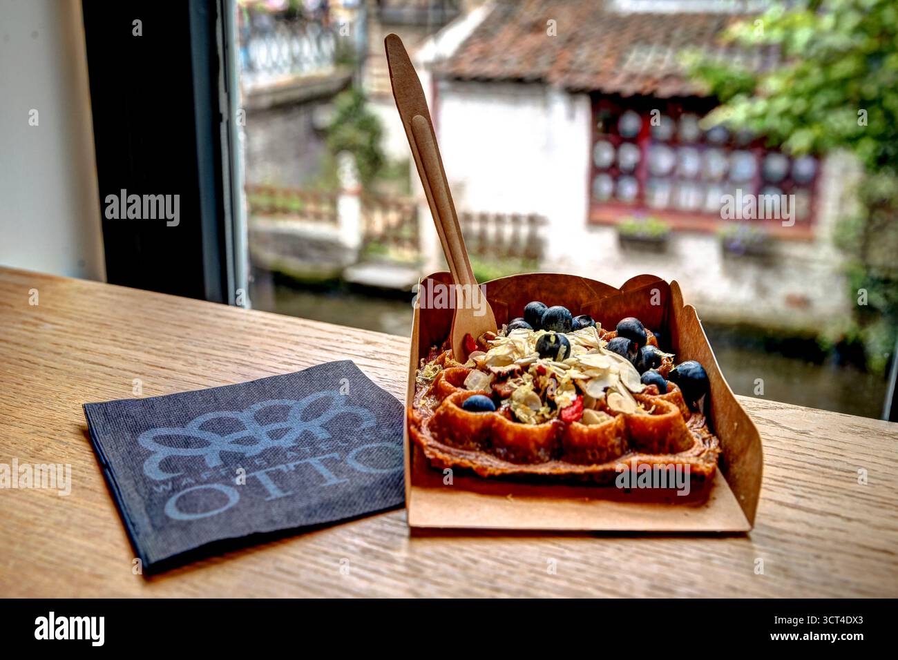 Frische belgische Waffeln mit Beeren, Nüssen und Sahne serviert in einem Café am Kanal in Brügge mit klassischen lokalen Aromen und Präsentationen Stockfoto