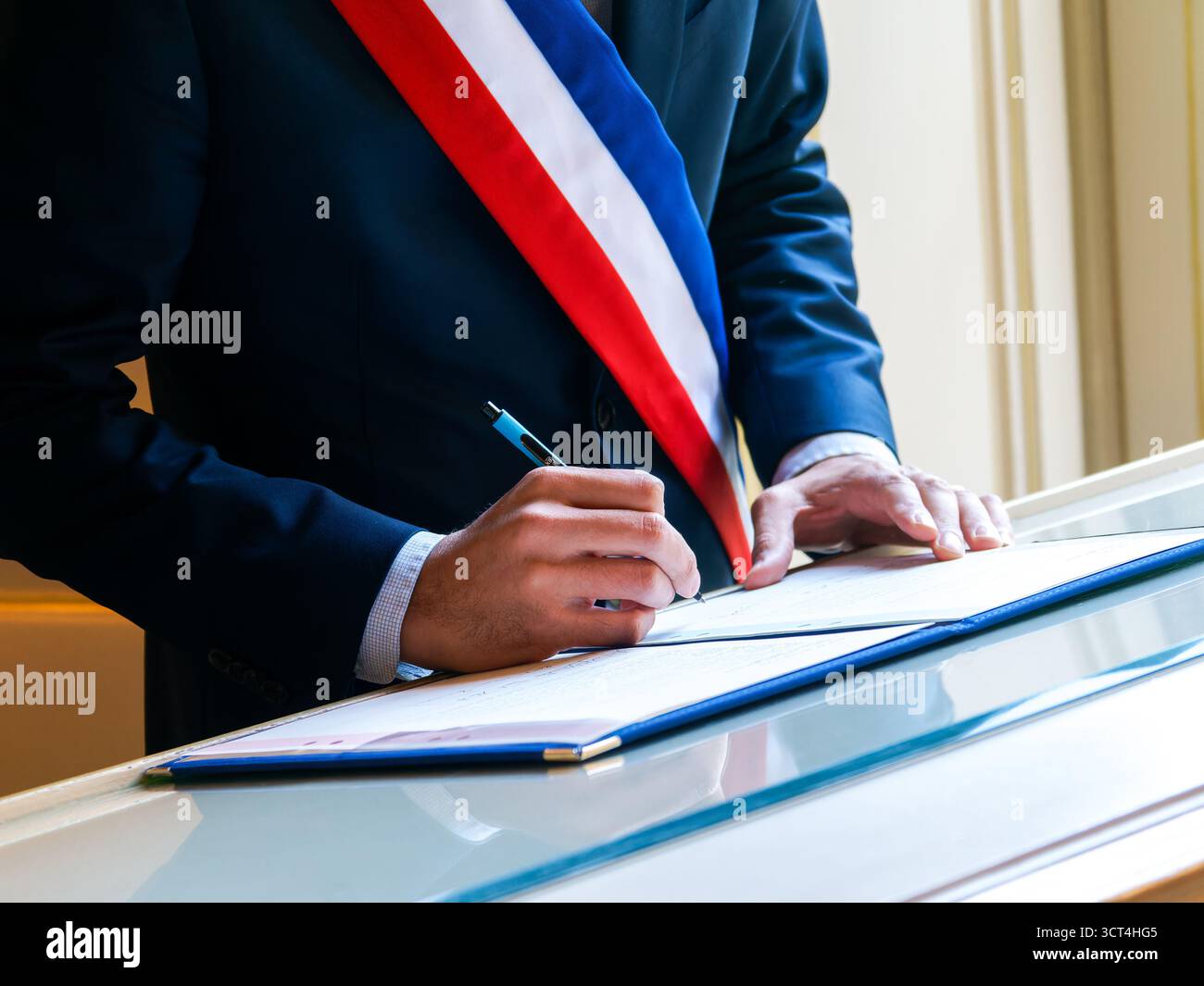 Französischer Bürgermeister unterzeichnet eine Zivilheiratsurkunde, Symbol für republikanische Werte und Rechtsunion. Stockfoto