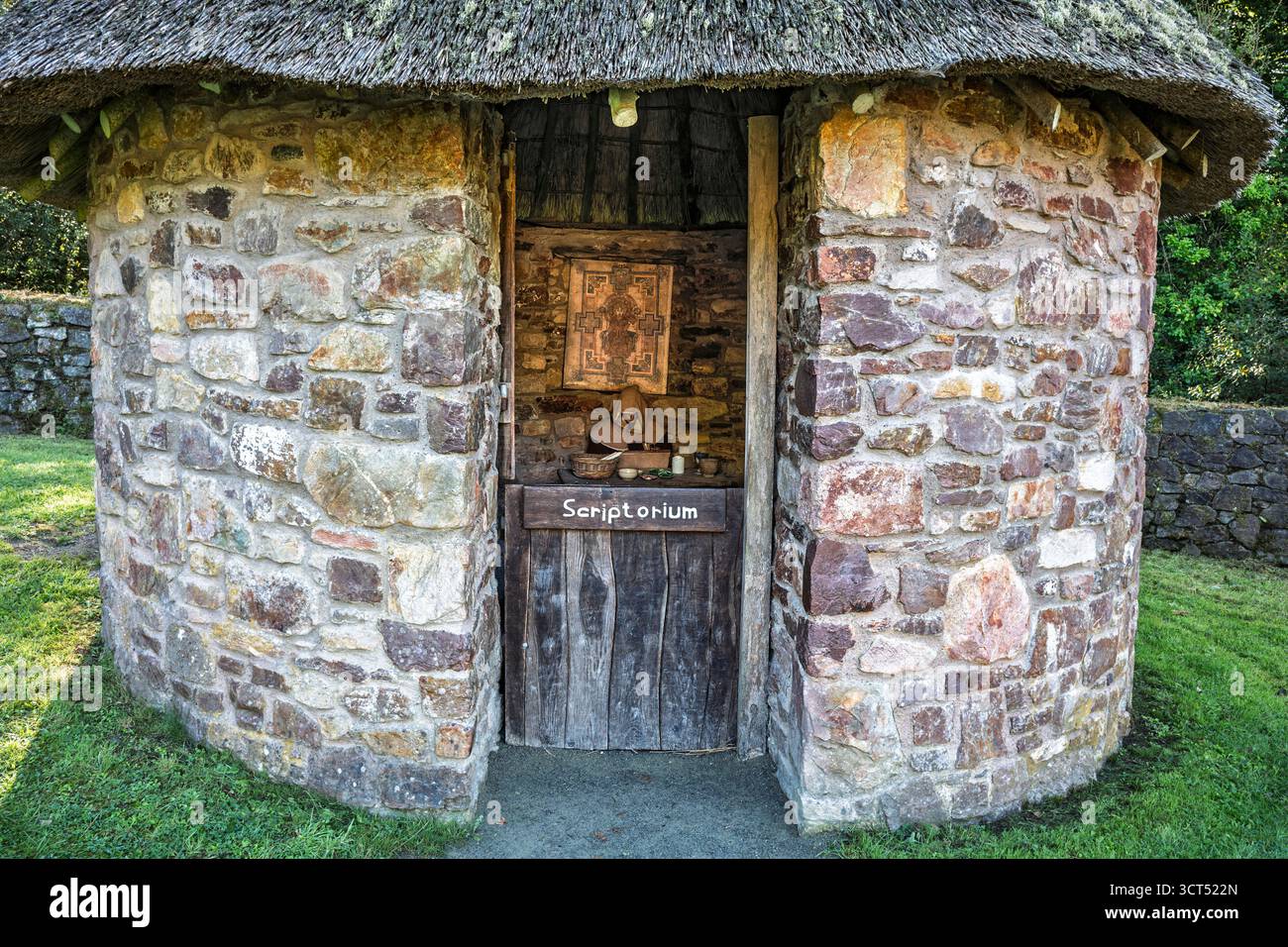Historisches Scriptorium-Gebäude, runde Steinmauern, konisches Strohdach, Blick auf die Landschaft, Irish National Heritage Park. Stockfoto