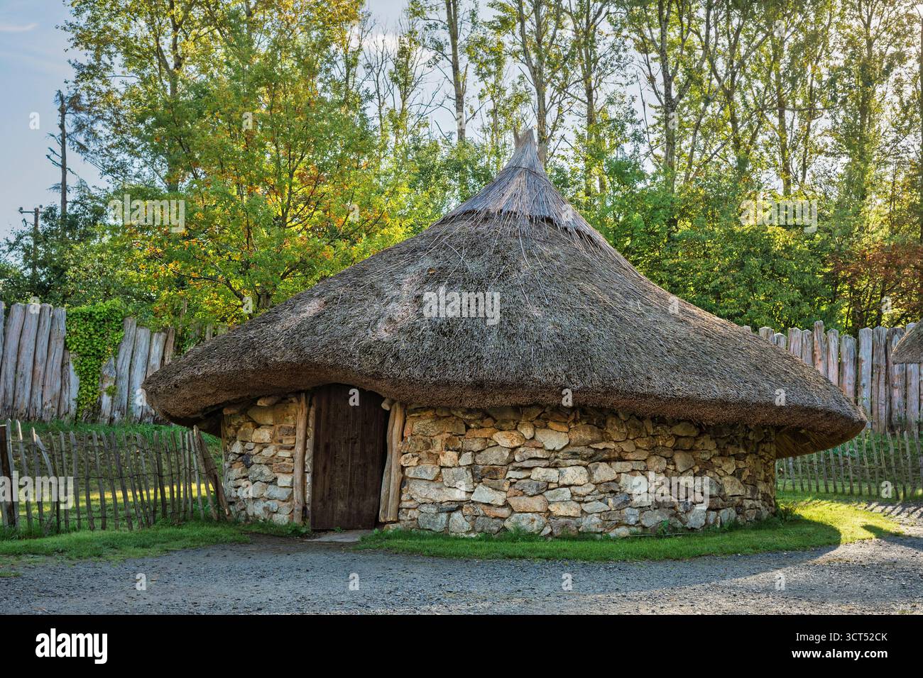 Prähistorisches irisches Roundhouse mit Trockenmauern, konischem Strohdach und Holzpalisade, Irish National Heritage Park. Stockfoto