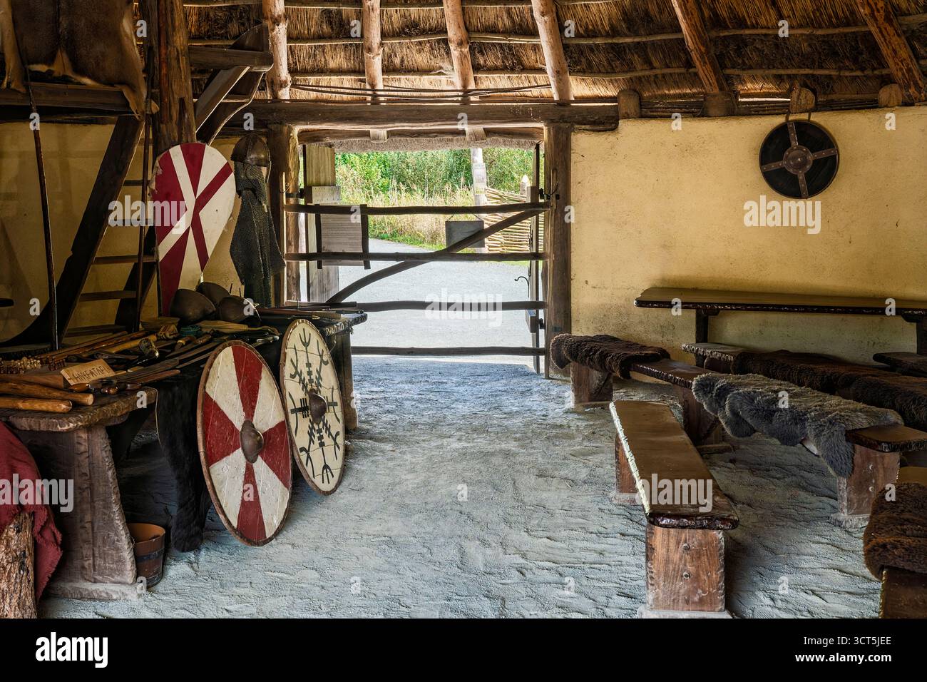 Viking Longhouse-Innenraum mit Eingang, Schilden und Pelzen, die Gemeinschafts- und Verteidigungsräume hervorheben, Wexford, Irland Stockfoto