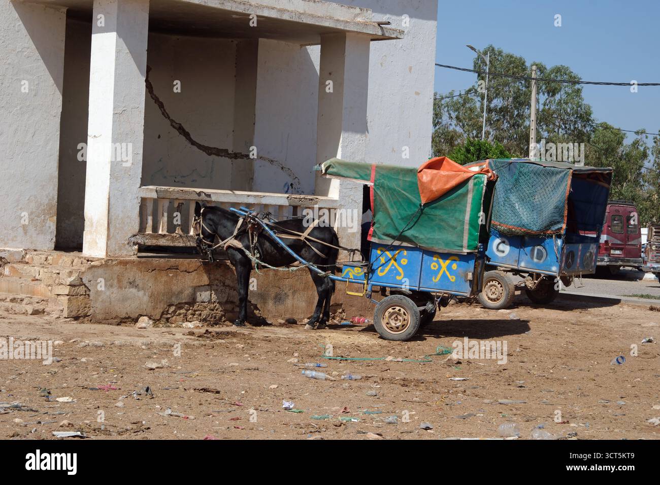 Ein Esel und ein Wagen warten vor einem Gebäude in einem marokkanischen Dorf in Nordafrika Stockfoto