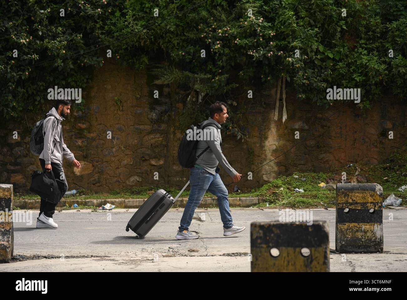 Kathmandu, Nepal. Oktober 2025. Passagiere werden am 5. Oktober 2025 an der Kontrollstelle Nagdhunga, einem der Hauptausgangsstellen von Kathmandu, festgestrandet, nachdem anhaltende Regenfälle Überschwemmungen und Erdrutsche ausgelöst hatten, die wichtige Autobahnen blockierten und Transportwege im ganzen Land störten. Trotz der Rückkehr des klaren Himmels in das Tal bleibt die Bewegung beschränkt, da die Behörden nach der Katastrophe daran arbeiten, Straßen wieder zu öffnen und den Verkehrsfluss zu steuern. Credit: Safal Prakash Shrestha/Alamy Live News Credit: Safal Prakash Shrestha/Alamy Live News Stockfoto
