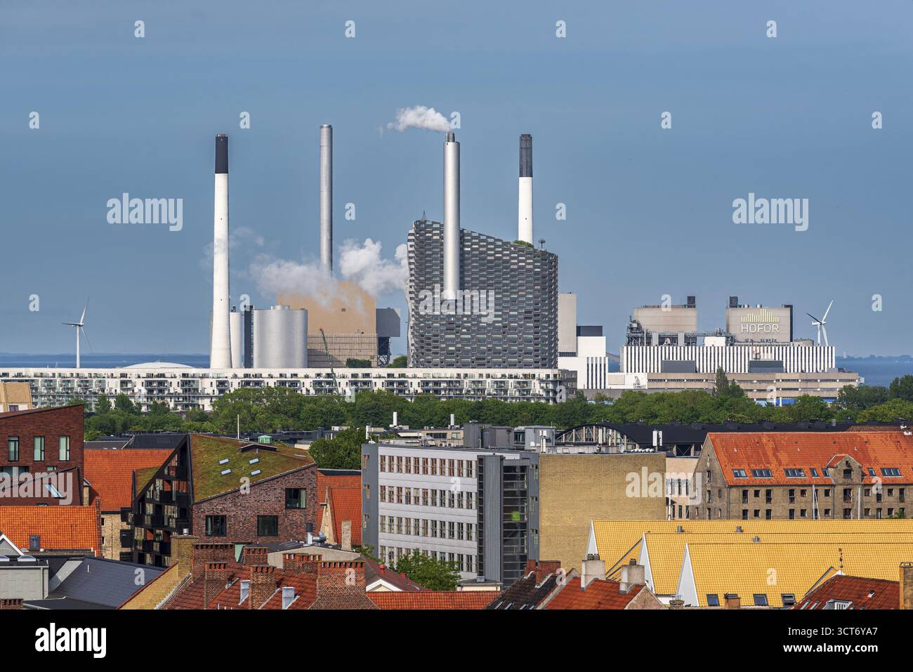 Stadtlandschaft mit mehreren Kaminen und einem Rauchkraftwerk im Hintergrund, umgeben von Ziegeldächern, Abfallverbrennungsanlage, Copenhill, Copenha Stockfoto