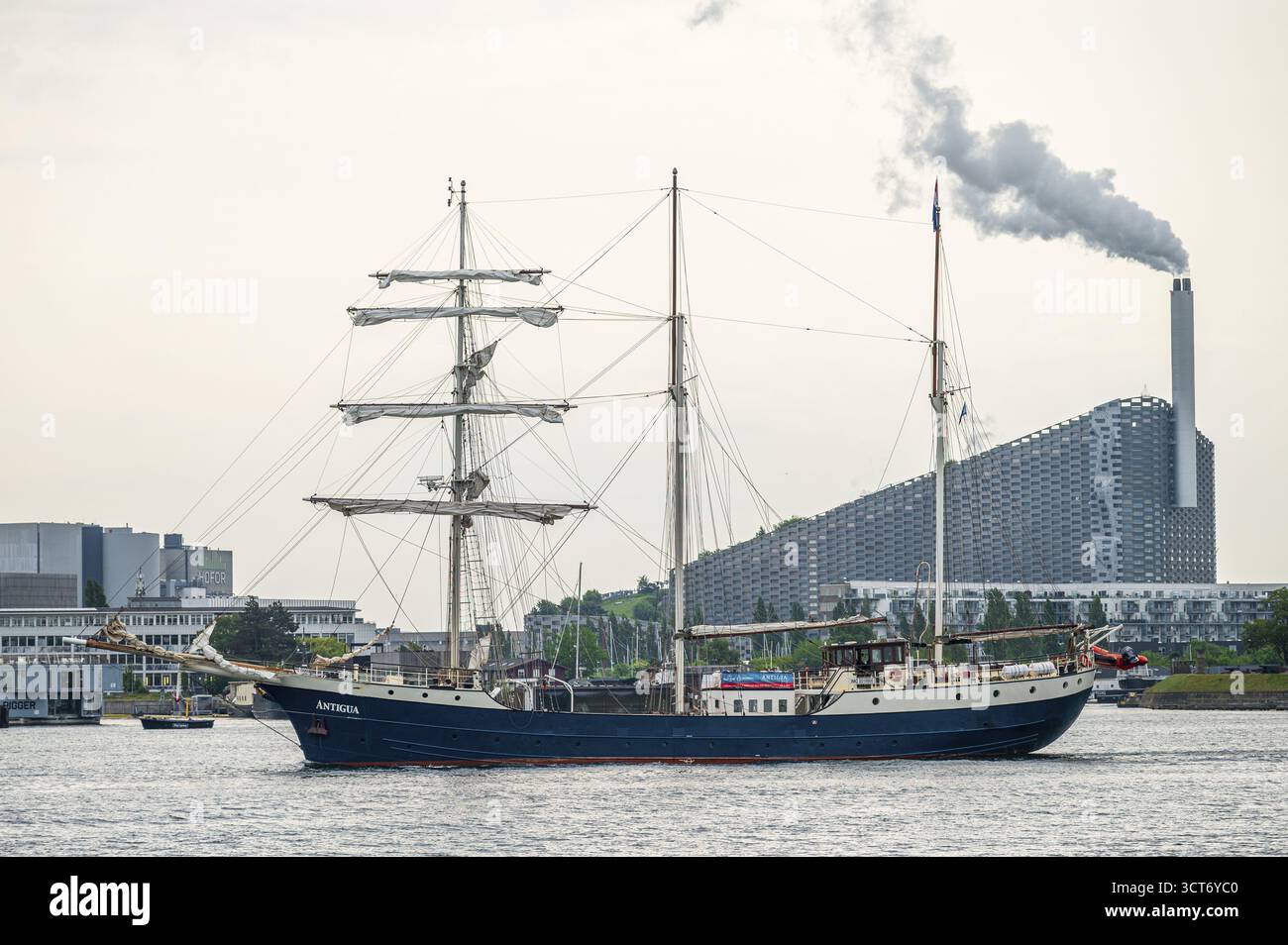 Nahaufnahme eines Segelschiffes mit rauchendem Kamin und industrieller Umgebung im Hintergrund, Müllverbrennungsanlage, Copenhill, Kopenhagen, Denm Stockfoto