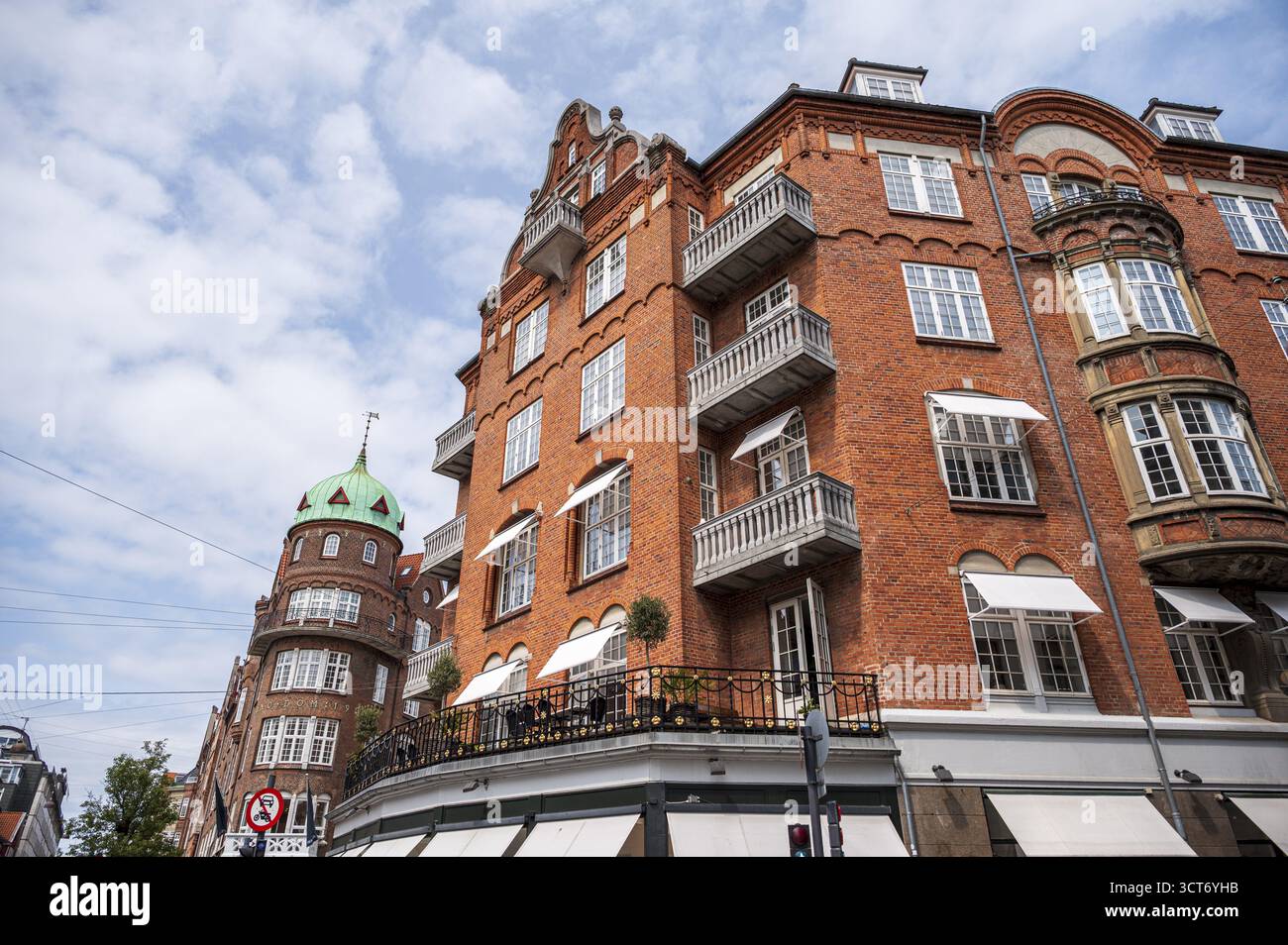 Großes Backsteinhaus mit vielen Fenstern und Balkonen unter blauem Himmel, Kopenhagen, Dänemark Stockfoto