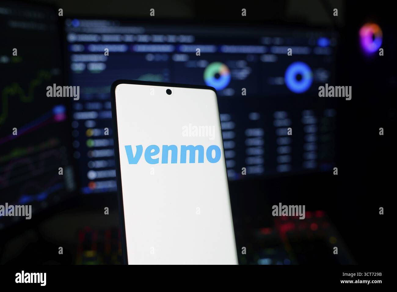 Ein Mobilgerät zeigt das Venmo-Logo mit analytischen Bildschirmen im Hintergrund Stockfoto