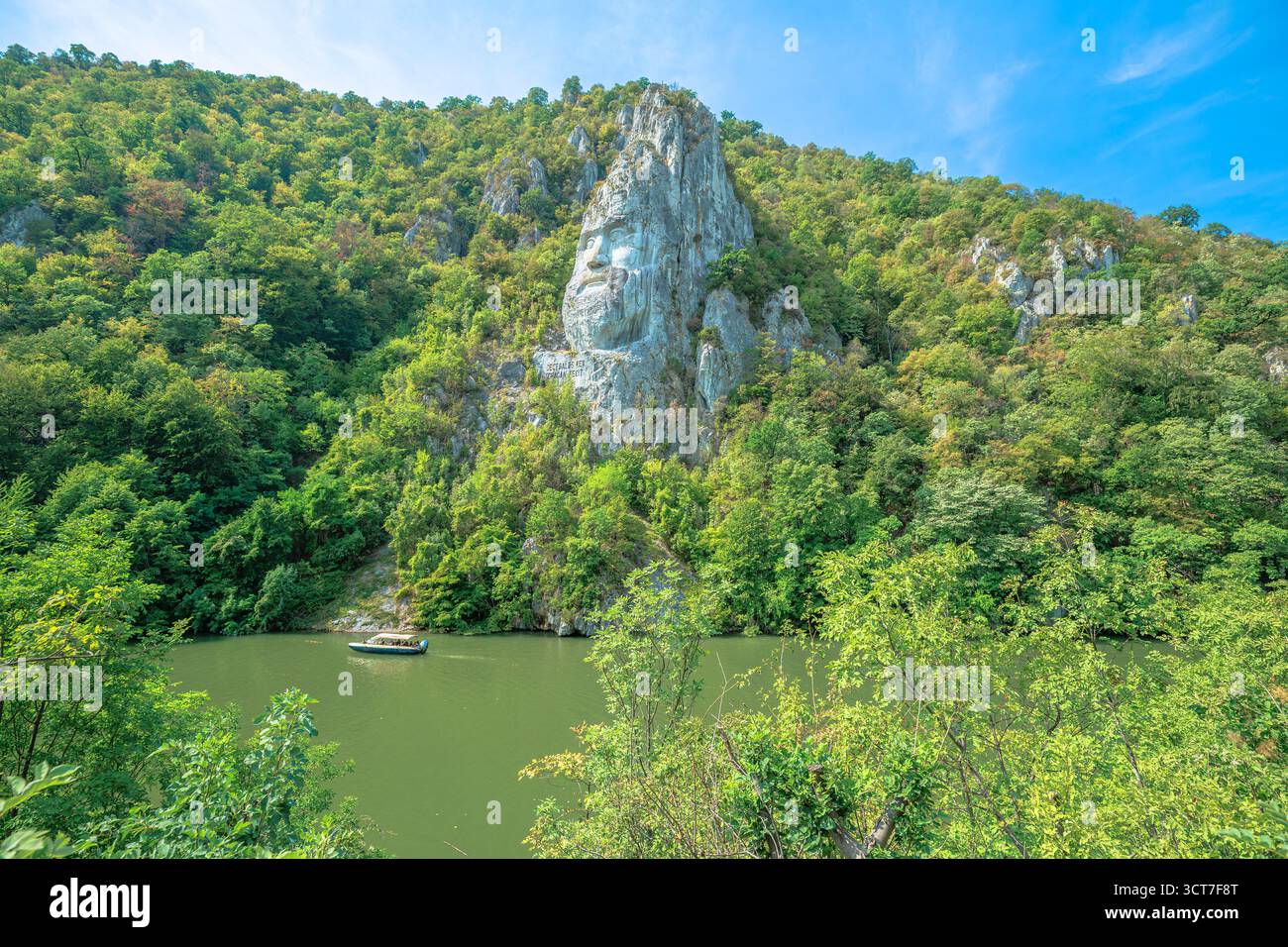 Rumänien - 1. September 2025: Donau fließt durch die Eiserne Tore-Schlucht in Rumänien, in die die Skulptur des alten dakischen Königs Decebalus eingemeißelt ist Stockfoto