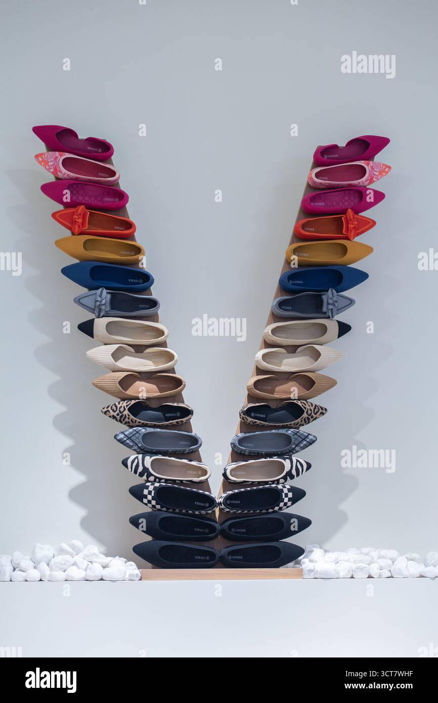 Marke VIVAIA. Umweltfreundliche Recycling-Schuhe. Damenschuhe sind in vertikaler V-Form im Einzelhandel in verschiedenen Farben und Designs angeordnet. Stockfoto