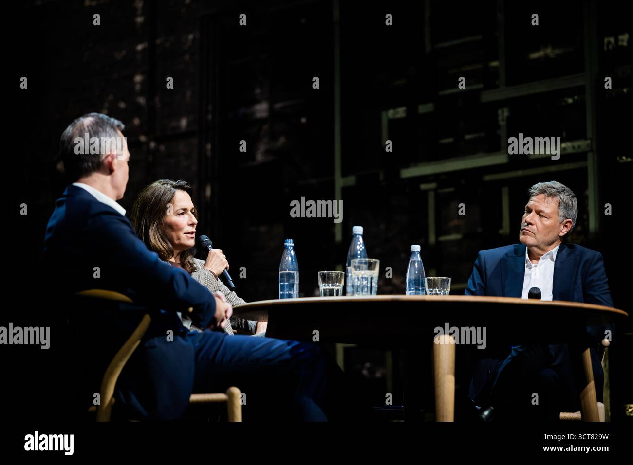 Berlin, Deutschland. Oktober 2025. Robert Habeck (Bündnis 90/die Grünen, (r-l)), Moderatorin und ehemalige Vizekanzlerin Anne will, Journalistin, und Volker Wissing (Nichtpartei), ehemaliger Bundesverkehrsminister, diskutieren bei "Habeck Live" im Berliner Ensemble. Zum Auftakt der Gesprächsreihe wird der ehemalige Vizekanzler Habeck das Thema "brauchen Demokratien einen Notfall?" diskutieren. Mit der Journalistin Anne will und dem Anwalt und Politiker Volker Wissing. Quelle: Christoph Soeder/dpa/Alamy Live News Stockfoto