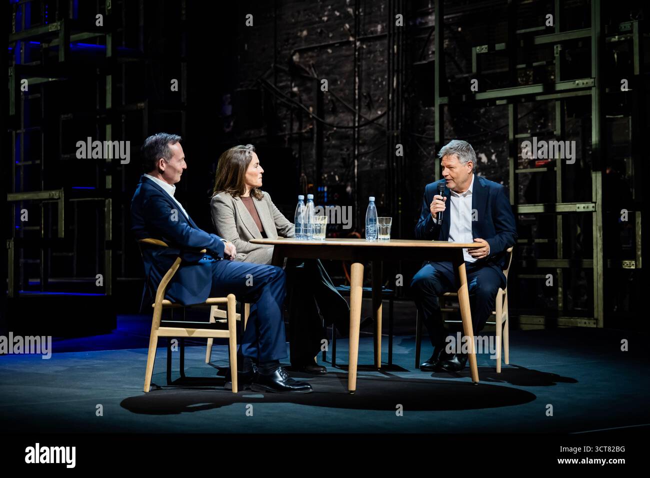 Berlin, Deutschland. Oktober 2025. Robert Habeck (Bündnis 90/die Grünen, (r-l)), Moderatorin und ehemalige Vizekanzlerin Anne will, Journalistin, und Volker Wissing (Nichtpartei), ehemaliger Bundesverkehrsminister, diskutieren bei "Habeck Live" im Berliner Ensemble. Zum Auftakt der Gesprächsreihe wird der ehemalige Vizekanzler Habeck das Thema "brauchen Demokratien einen Notfall?" diskutieren. Mit der Journalistin Anne will und dem Anwalt und Politiker Volker Wissing. Quelle: Christoph Soeder/dpa/Alamy Live News Stockfoto