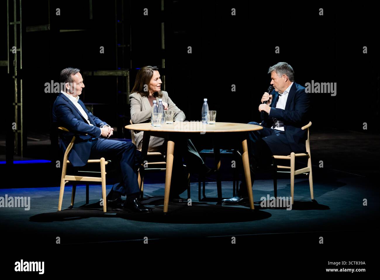 Berlin, Deutschland. Oktober 2025. Robert Habeck (Bündnis 90/die Grünen, (r-l)), Moderatorin und ehemalige Vizekanzlerin Anne will, Journalistin, und Volker Wissing (Nichtpartei), ehemaliger Bundesverkehrsminister, diskutieren bei "Habeck Live" im Berliner Ensemble. Zum Auftakt der Gesprächsreihe wird der ehemalige Vizekanzler Habeck das Thema "brauchen Demokratien einen Notfall?" diskutieren. Mit der Journalistin Anne will und dem Anwalt und Politiker Volker Wissing. Quelle: Christoph Soeder/dpa/Alamy Live News Stockfoto
