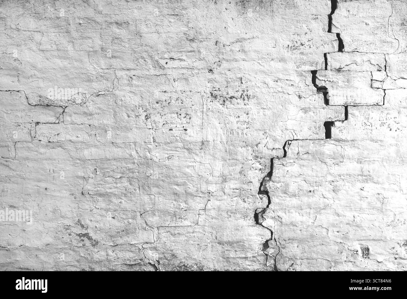 Gerissene und beschädigte alte Ziegelwand mit sichtbarem Verschleiß und Textur. Getragenes urbanes Muster, Stockfoto