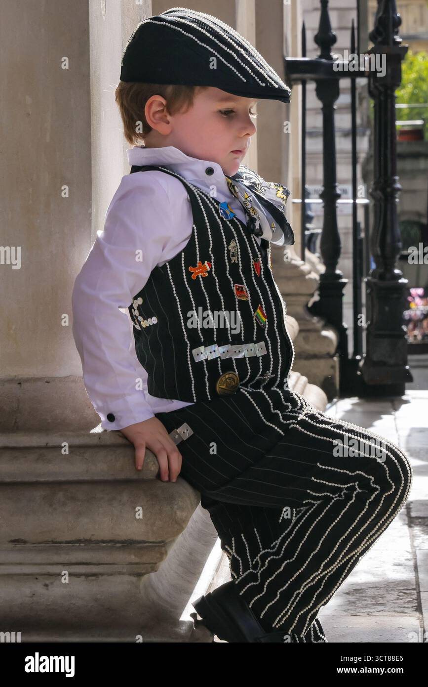 London, Großbritannien. Oktober 2025. Ein kleiner Perlprinz ruht sich aus. Die ursprüngliche Pearly Kings and Queens Association feiert ihr jährliches Harvest Festival in der St. Martin-in-the-Fields Kirche im Zentrum von London. Der Verein entstand 1875. Die Pearly Kings and Queens geben ihre Zeit frei, um Gelder für benannte Wohltätigkeitsorganisationen zu sammeln, um anderen eine bessere Lebensweise zu bieten und diejenigen zu unterstützen, die Hilfe benötigen. Quelle: Imageplotter/Alamy Live News Stockfoto