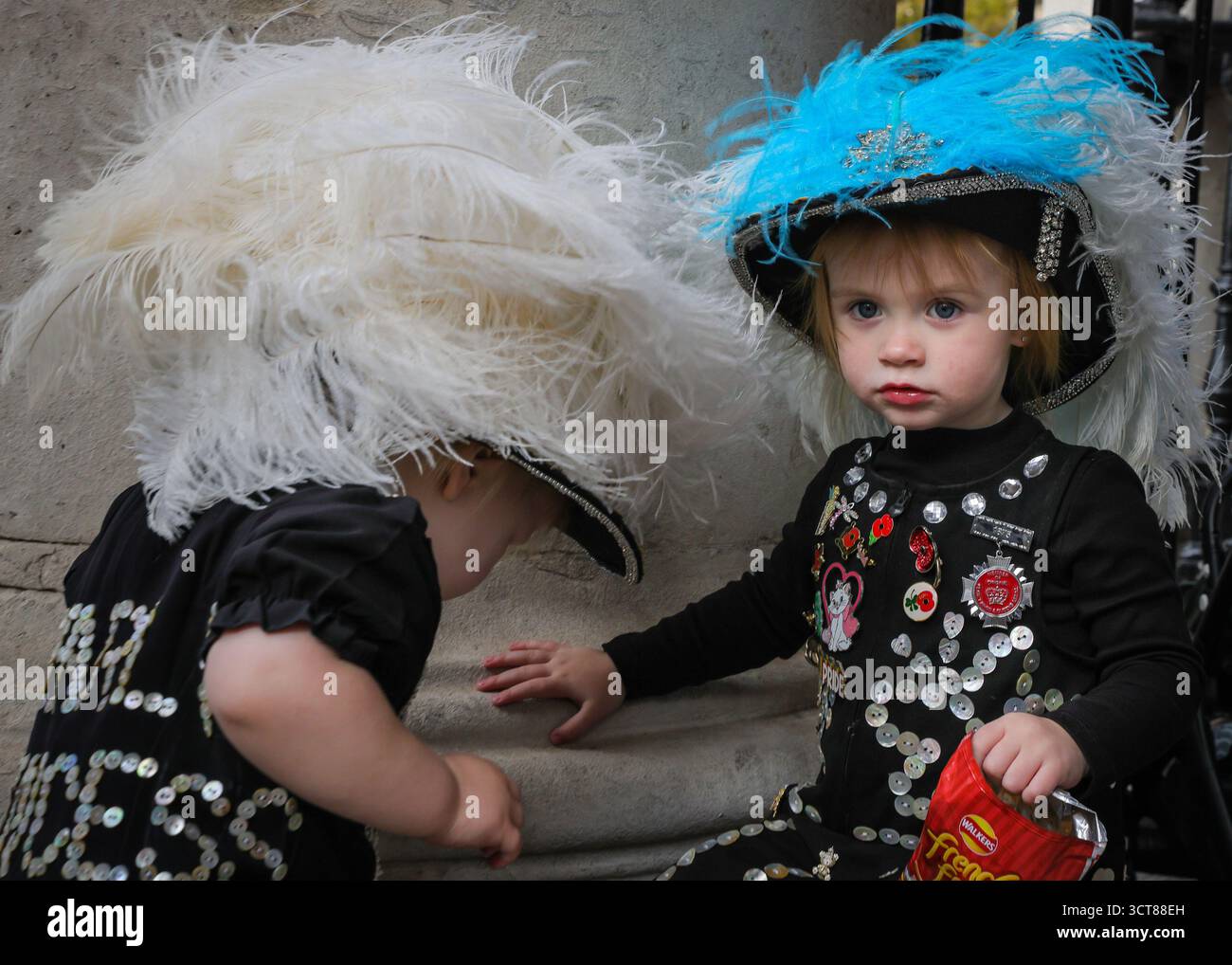 London, Großbritannien. Oktober 2025. Phoebe und Olive, beide 2 und Pearly Princesses, sind die jüngsten Mitglieder, die teilnehmen. Die ursprüngliche Pearly Kings and Queens Association feiert ihr jährliches Harvest Festival in der St. Martin-in-the-Fields Kirche. Der Verein entstand 1875. Die Pearly Kings and Queens geben ihre Zeit frei, um Gelder für benannte Wohltätigkeitsorganisationen zu sammeln, um anderen eine bessere Lebensweise zu bieten und diejenigen zu unterstützen, die Hilfe benötigen. Quelle: Imageplotter/Alamy Live News Stockfoto