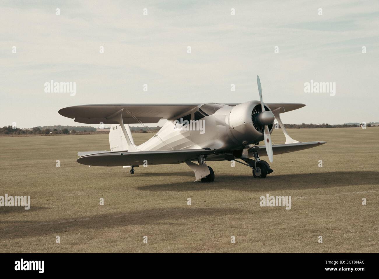 Klassisches weißes Doppeldeckerflugzeug parkt auf dem Grasflugplatz in Duxford Stockfoto