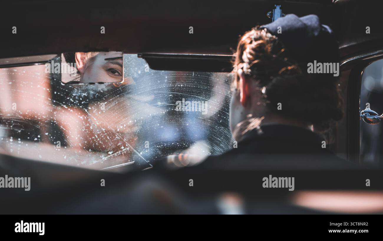 Person, die die Windschutzscheibe des Autos mit Wasserspray und Tuch wäscht Stockfoto