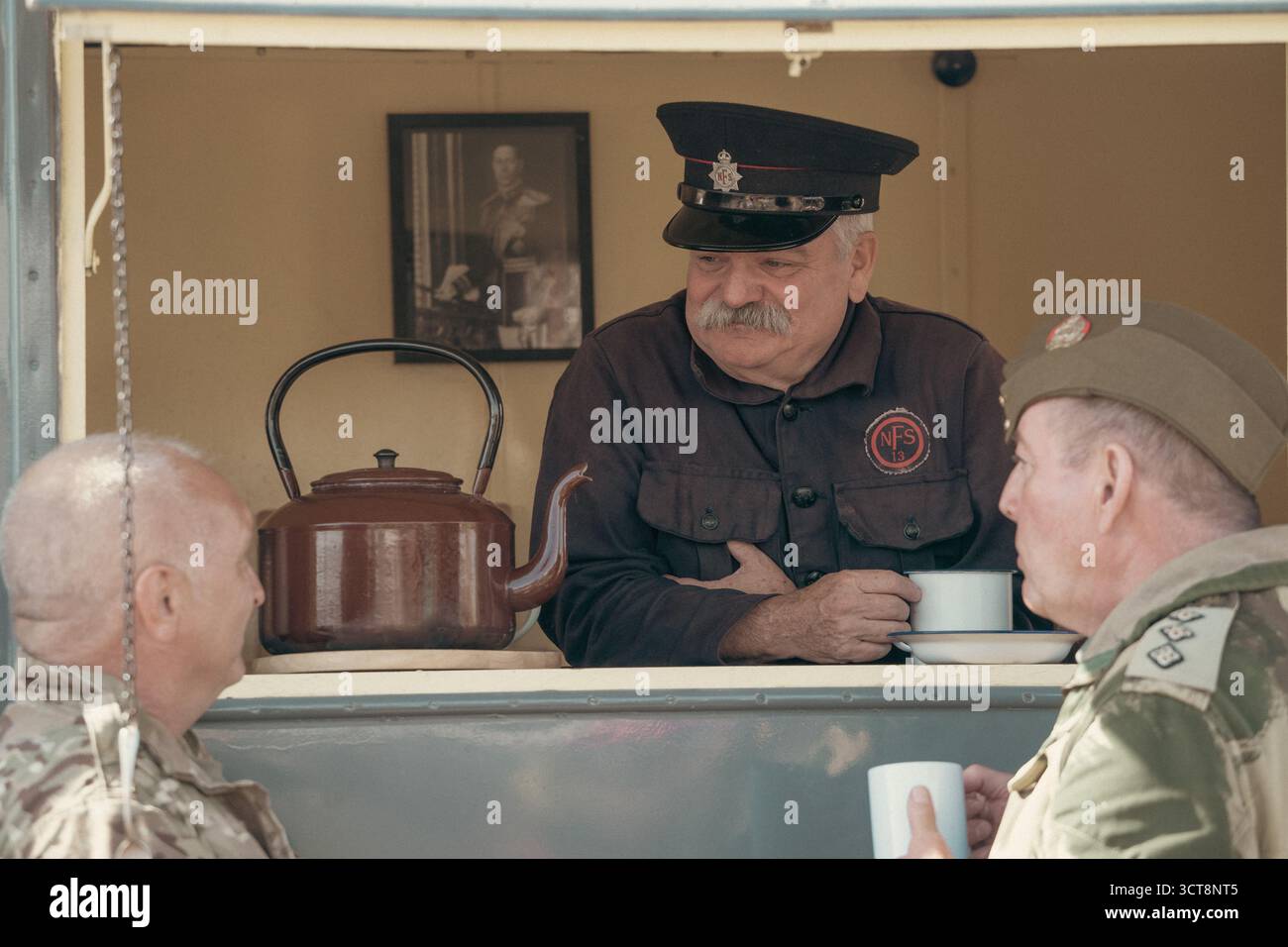 Nachbildung in Uniform der National Fire Service, serviert Tee in historischer Ausstellung Stockfoto