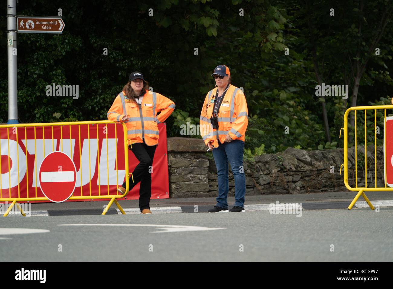 Straßenmarschälle in übersichtlichen Jacken, die beim Isle of man-Event Verkehrsbarrieren verwalten Stockfoto