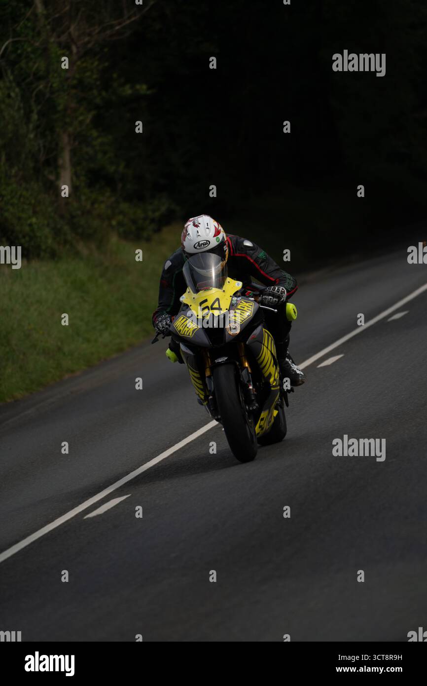 Rennmotorradfahrer Nummer 54 auf der Isle of man TT-Strecke durch die Landschaft Stockfoto