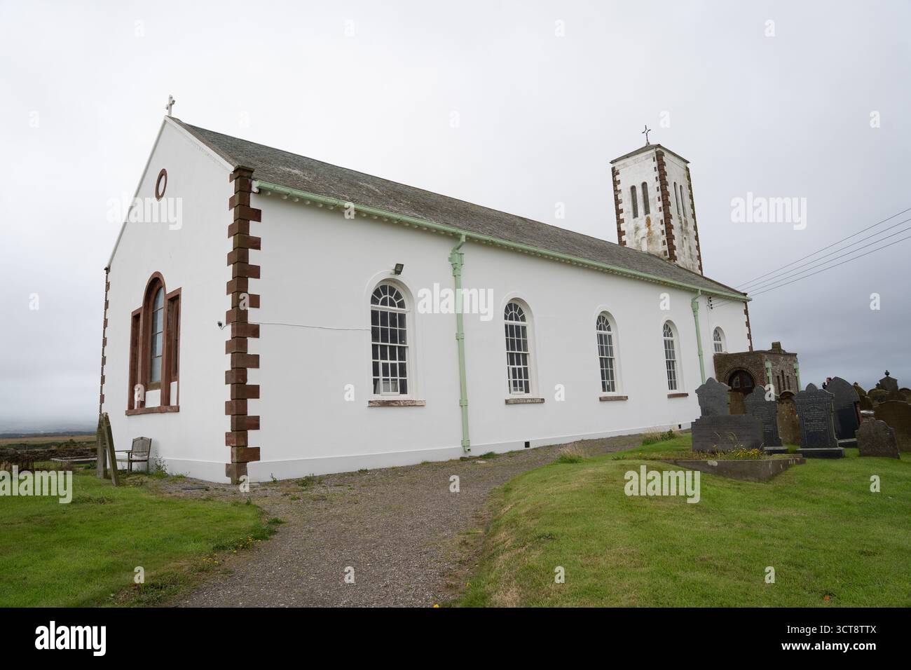 Weiße ländliche Kirche mit Glockenturm und Friedhof auf der Isle of man Stockfoto