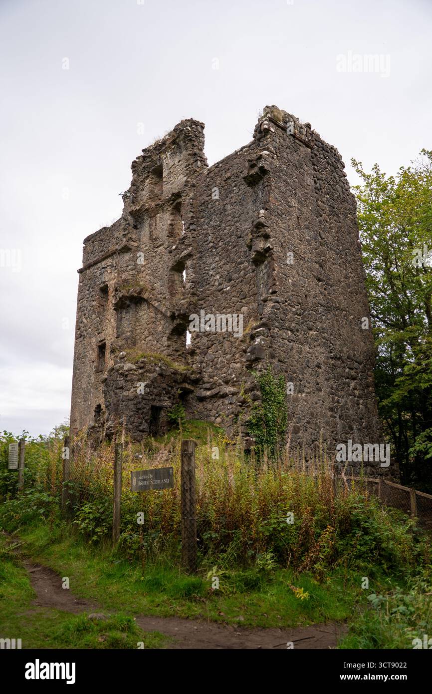 Alte Ruine Burgturm mit moosbedeckten Steinmauern und Holzzaun in der schottischen Landschaft Stockfoto